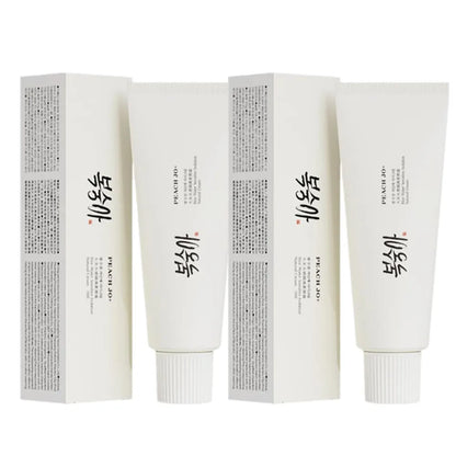 Two white SPF50+ Rice Extract Moisturizing Cream tubes and matching boxes with black text.