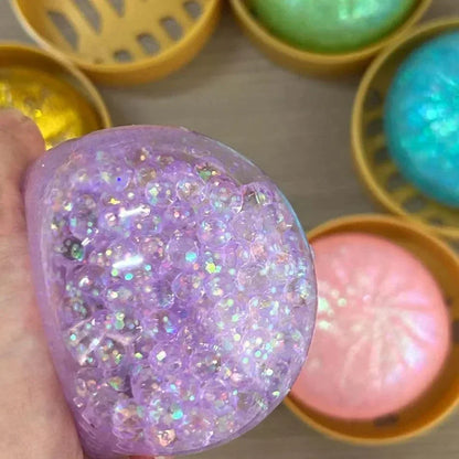 Purple sparkly squishy fidget toy in a bamboo steamer for stress relief and sensory play.