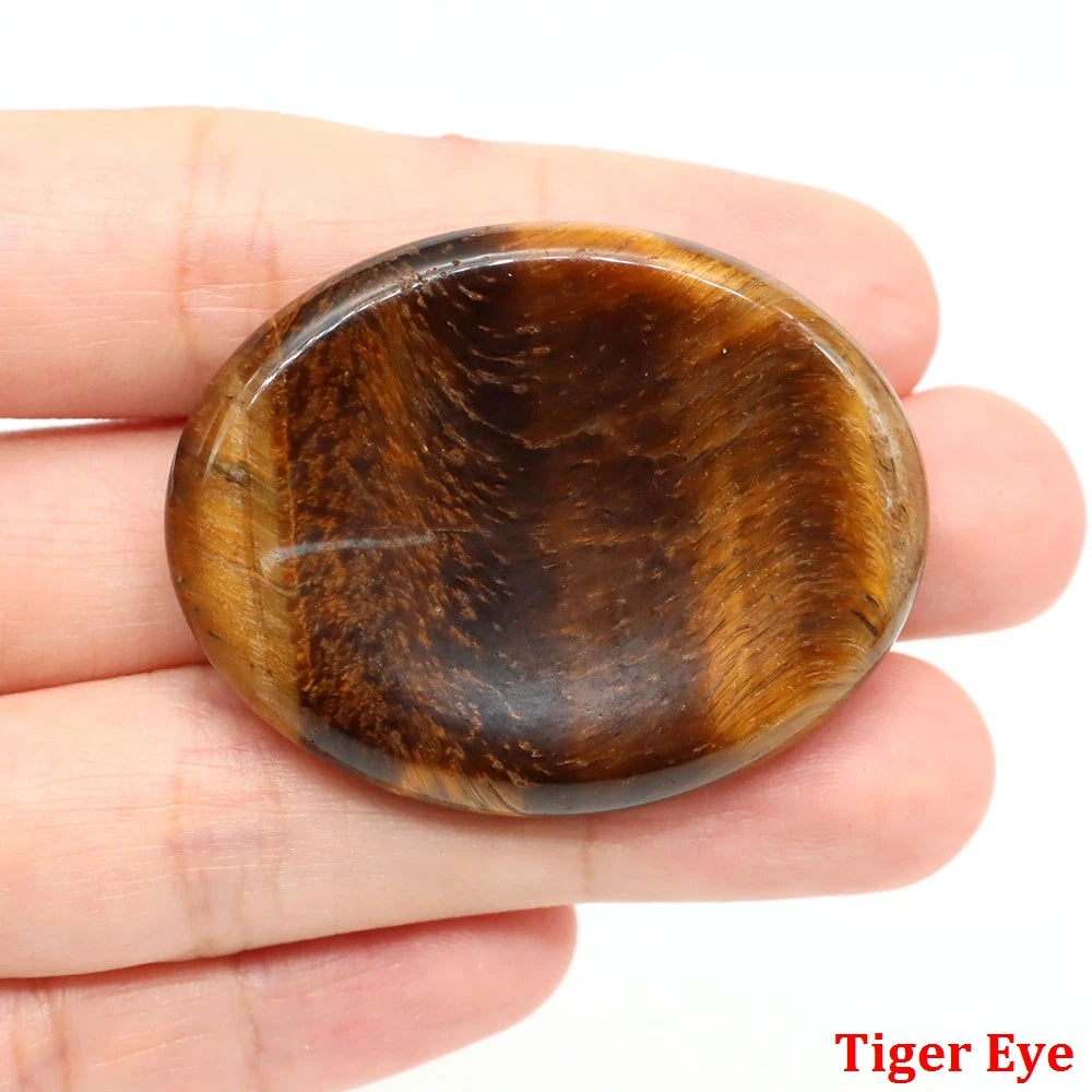 Smooth, oval brown tiger eye home decor stone held in a palm for focused meditation.