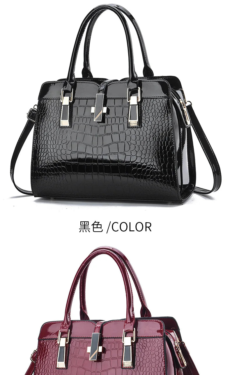 Black and dark red crocodile-pattern leather handbags with dual top handles, gold hardware, and a center clasp.