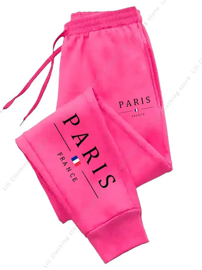 Bright pink fleece jogger pants with Paris France graphic for cozy lounging with a stretchy drawstring waist.