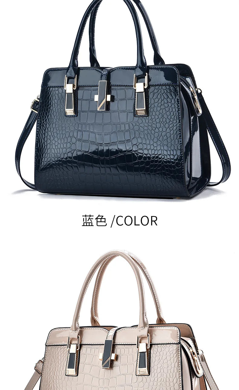 Glossy dark blue and beige crocodile-pattern leather handbags with dual top handles and gold-tone hardware.
