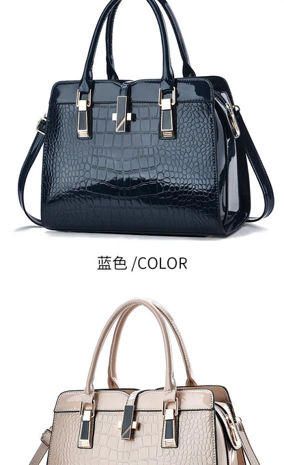 Glossy dark blue and beige crocodile-pattern leather handbags with dual top handles and gold-tone hardware.
