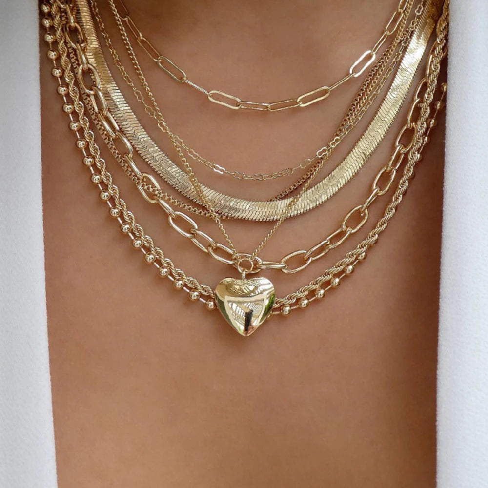 Layered necklace set featuring multi-strand chains and a heart pendant