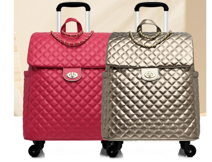 Two quilted wheeled travel bags in hot pink and gold with gold chain accents and twist-lock closures.