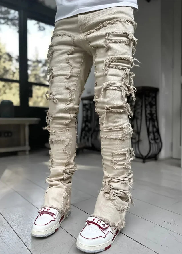 Beige denim jeans featuring heavy ripped detailing and a fitted silhouette for casual everyday wear.