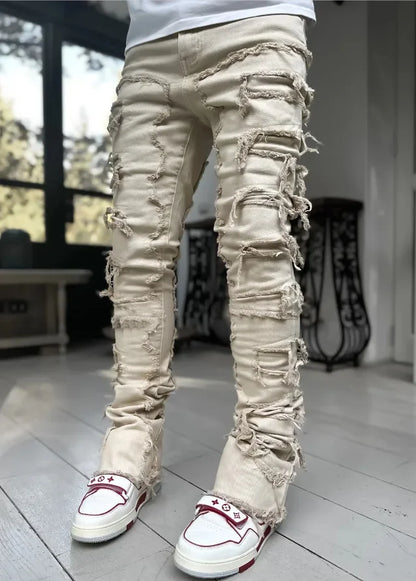 Beige denim jeans featuring heavy ripped detailing and a fitted silhouette for casual everyday wear.