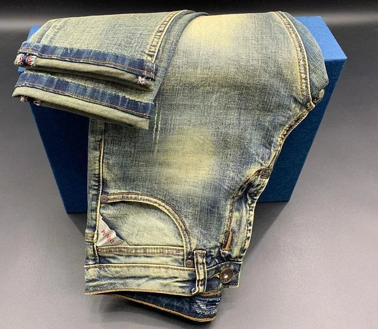 Faded blue wash tapered jeans in stretchy denim with a button fly for daily comfort.