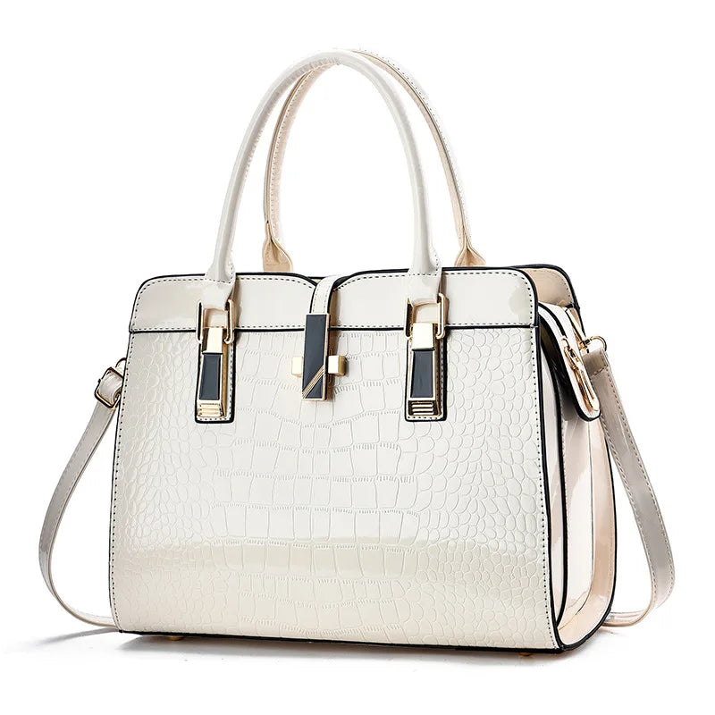 Off-white patent leather crocodile-pattern tote bag with dual handles, gold hardware, and a removable shoulder strap.