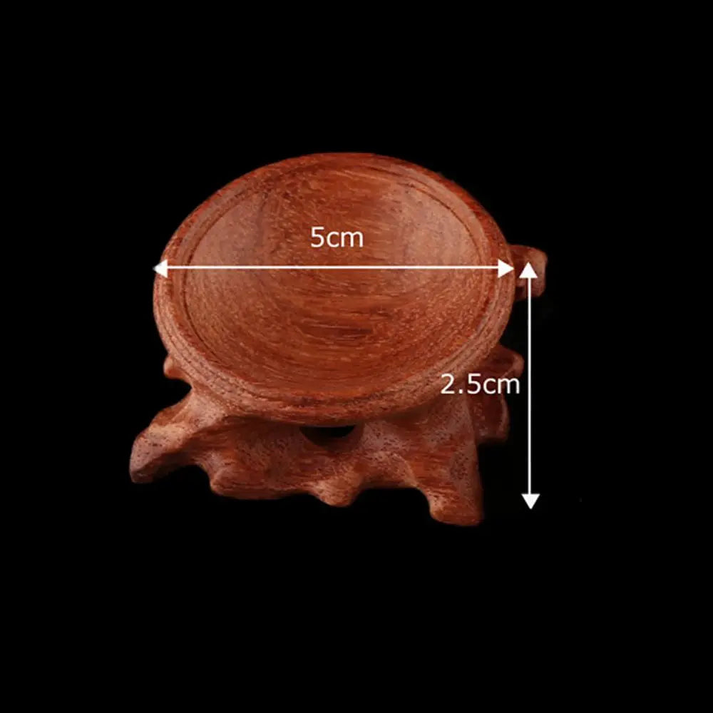 Brown wooden crystal ball base with carved root-style legs, measuring 5 cm wide and 2.5 cm high.