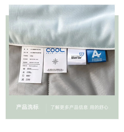 Light blue and grey cooling comforter with fabric care tags for hot sleepers.