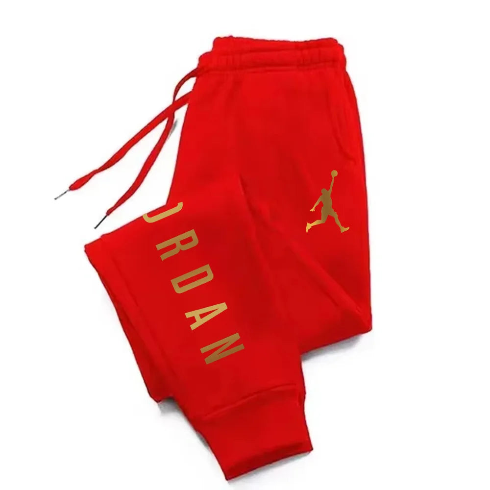 Red midweight joggers with gold lettering, drawstring waist and fitted cuffs for athletic training.
