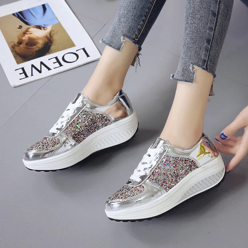 Silver metallic and multi-color glitter lace-up platform wedge sneakers with white soles.