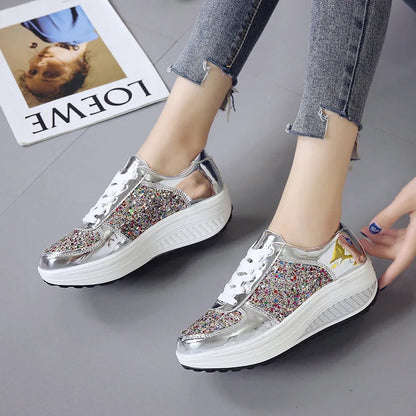 Silver metallic and multi-color glitter lace-up platform wedge sneakers with white soles.