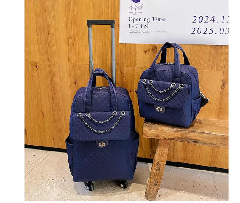 Two navy blue quilted rolling backpacks with chain-accented front pockets and top handles.