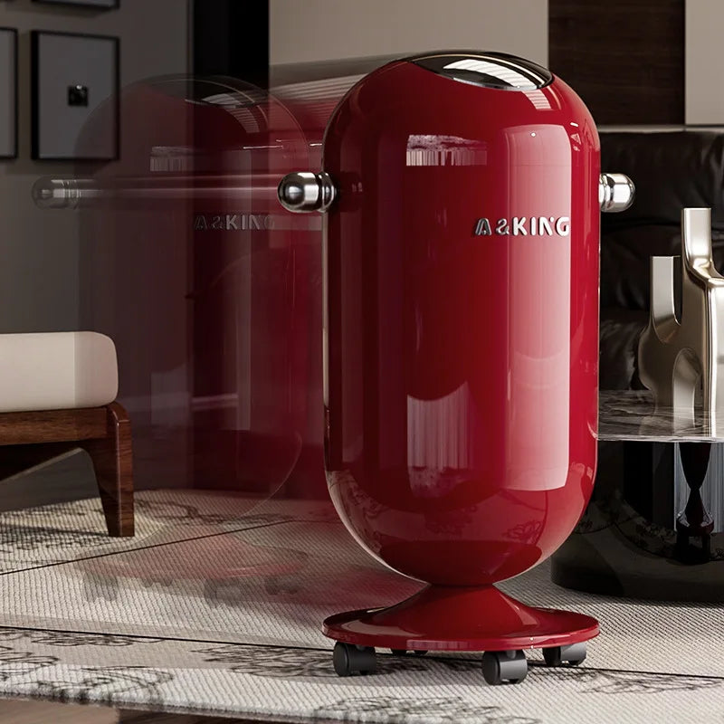 Glossy red capsule-shaped trash can on small wheels in a room.