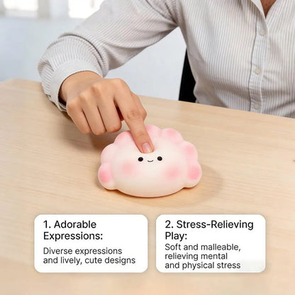 Soft, pink-and-white silicone dumpling squishy fidget toy used for stress relief on a desk.