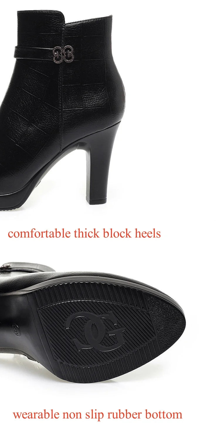 Black leather ankle boot with block heel, decorative strap with double-ring buckle, and textured rubber sole.