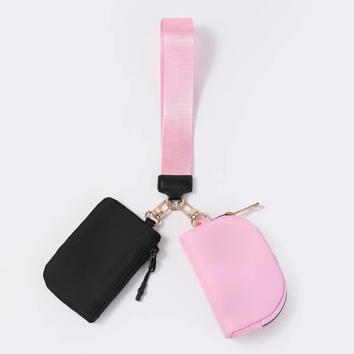 Pink and black nylon dual pouch with a zip closure and wristlet for carrying daily essentials.