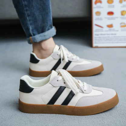 Off-white canvas and suede sneakers with black stripes and gum soles, these breathable casual training shoes.