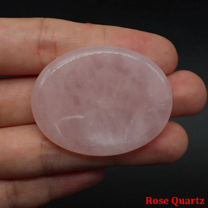 Smooth, oval, light pink rose quartz home decor stone held in a hand for meditation.