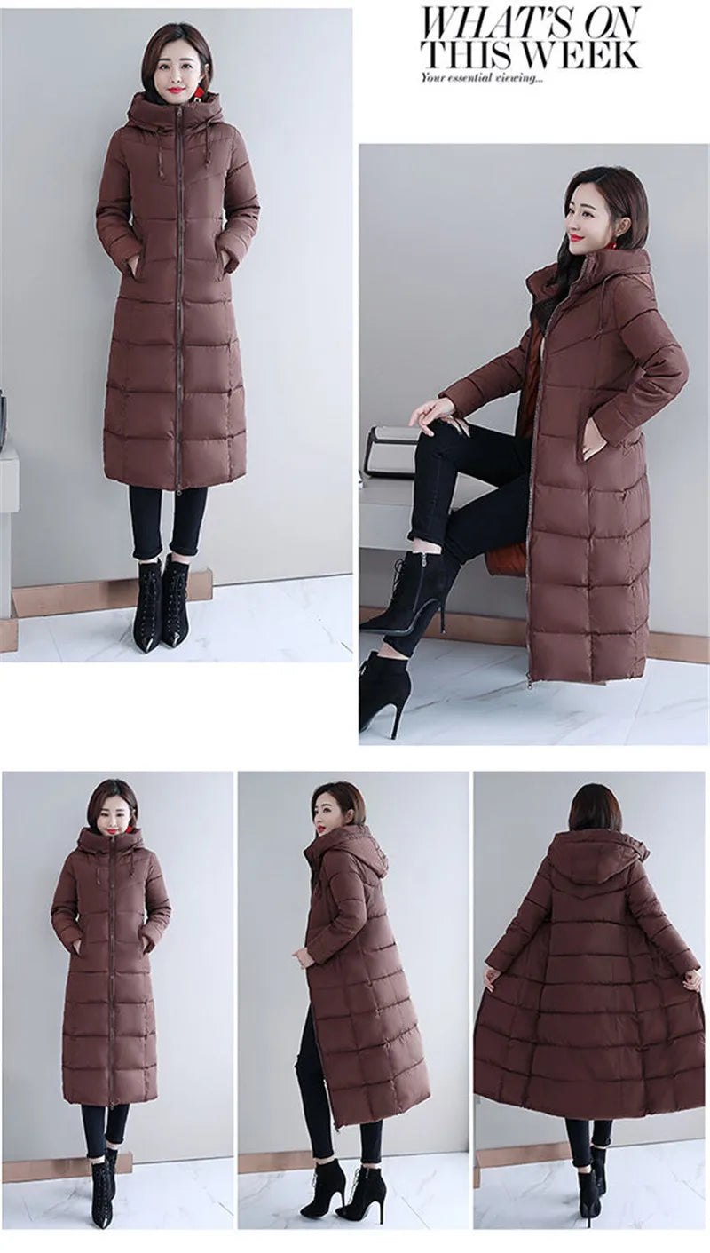 A woman models a long, brown quilted puffer coat with a hooded, zippered design.