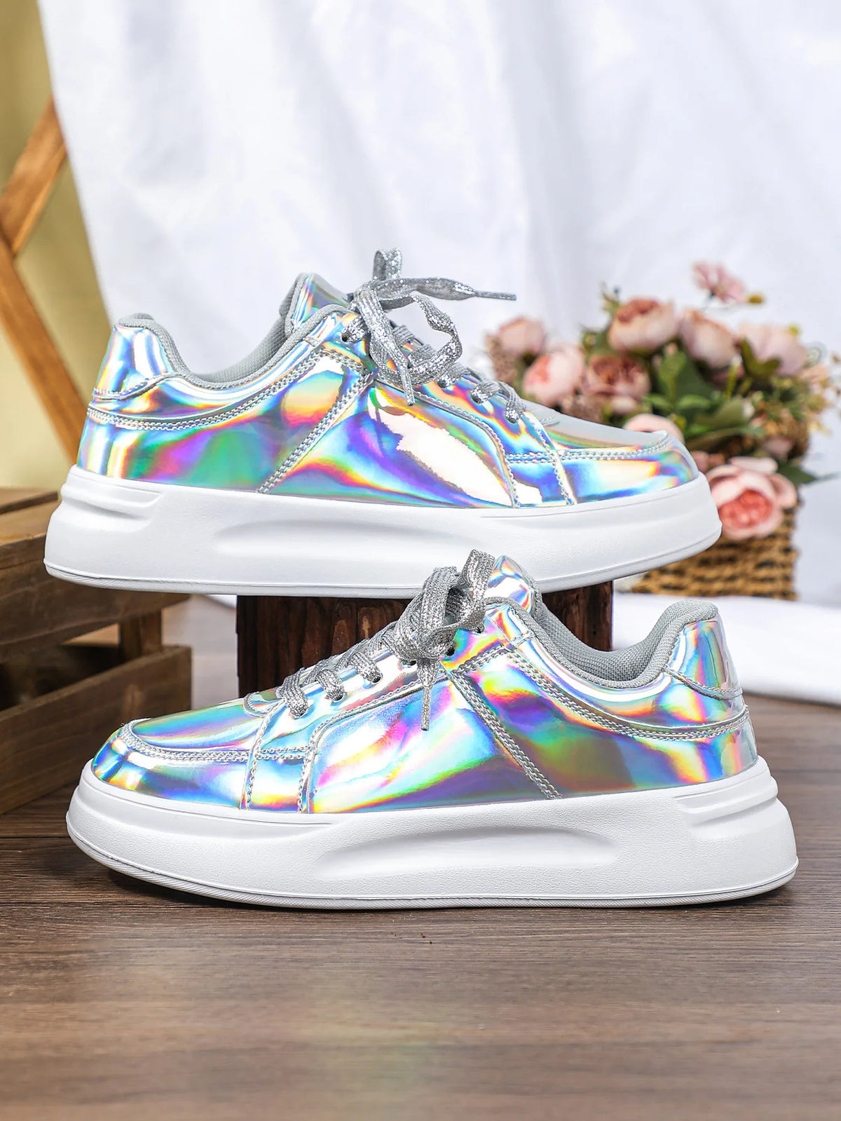 Metallic holographic lace-up sneakers with thick white soles and sparkly silver laces.