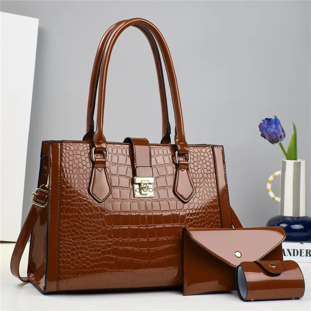 Brown patent leather crocodile-pattern tote bag with top handles, closure clasp, and matching small wallet and case.