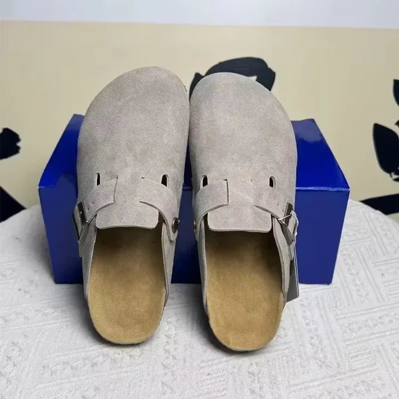 Light grey suede slip-on mules with adjustable buckle straps and non-slip soles for casual wear.