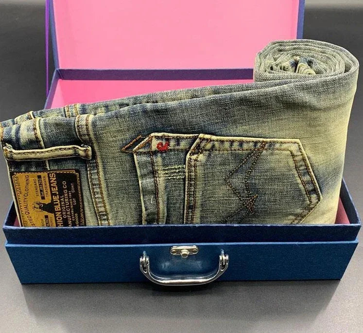 Faded blue stretchy tapered jeans with back pockets folded in a blue box for daily wear.