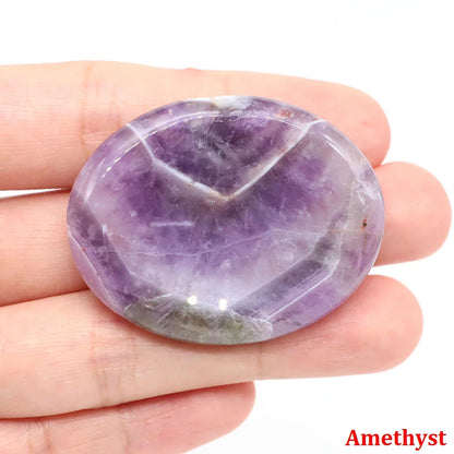 Smooth purple hand-carved stone home decor piece held in hand for meditation.