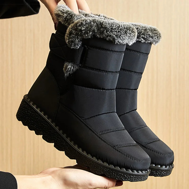 Black waterproof snow boots with gray faux fur trim, quilted shaft, and textured rubber sole.