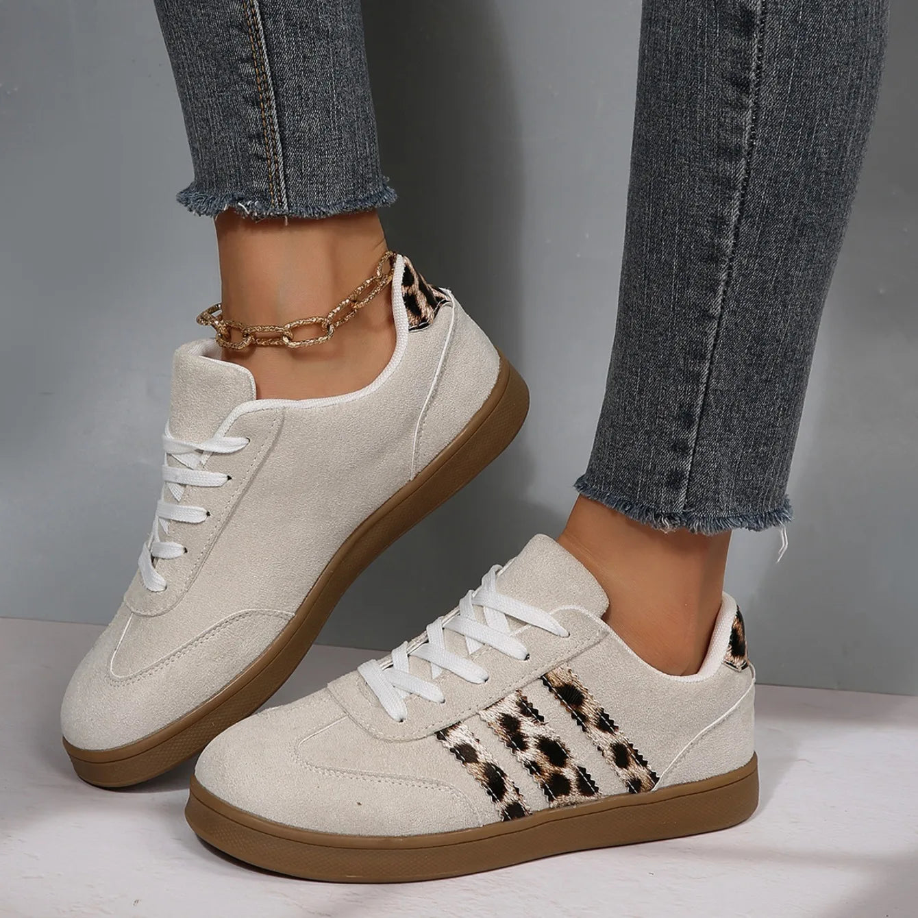 Beige suede sneakers with leopard print stripes and white laces, featuring cushioned insoles for outdoor walking.