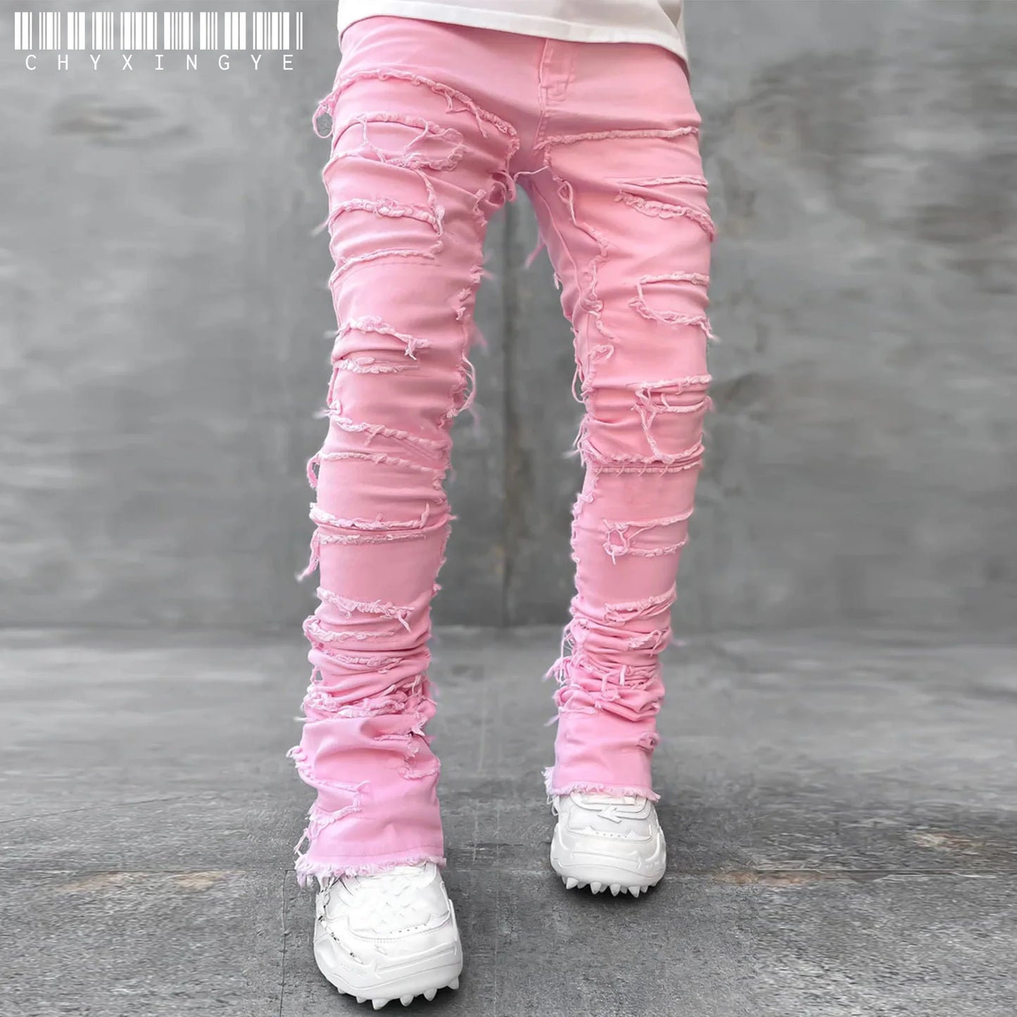 Pink fitted denim jeans with distressed patchwork details and frayed edges for a casual street style look.