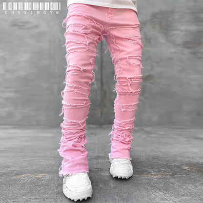 Pink fitted denim jeans with distressed patchwork details and frayed edges for a casual street style look.