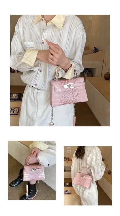 Pink croc-embossed faux leather structured diaper bag with silver chain strap and zip closure for organized travel.