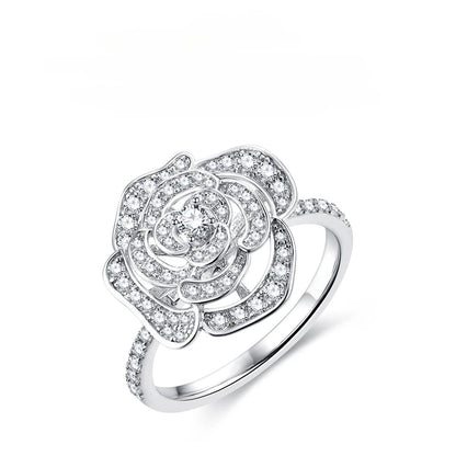 Silver flower ring with a paved camellia design set with small moissanite crystals.