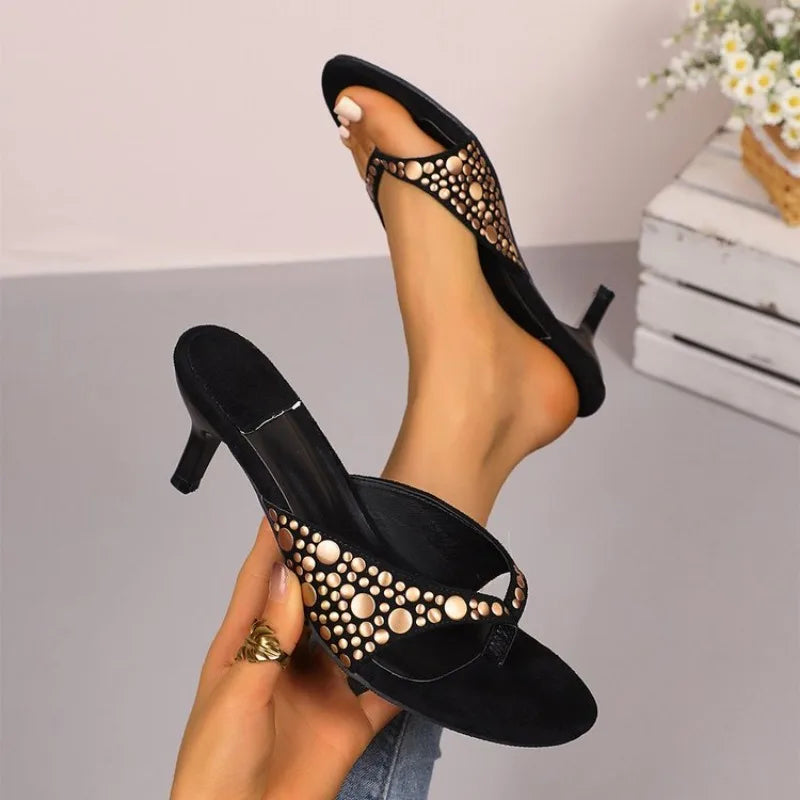 Black suede stiletto sandals with gold rivet details and slip-on design for formal events.