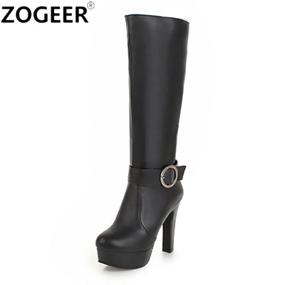 Black knee-high platform boot in smooth faux leather featuring a chunky high heel and ankle strap with round metal buckle.