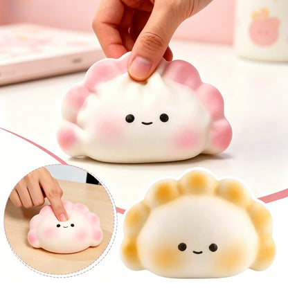 Soft, white and pink rubber dumpling squishy fidget toy with a smiling face for portable stress relief.