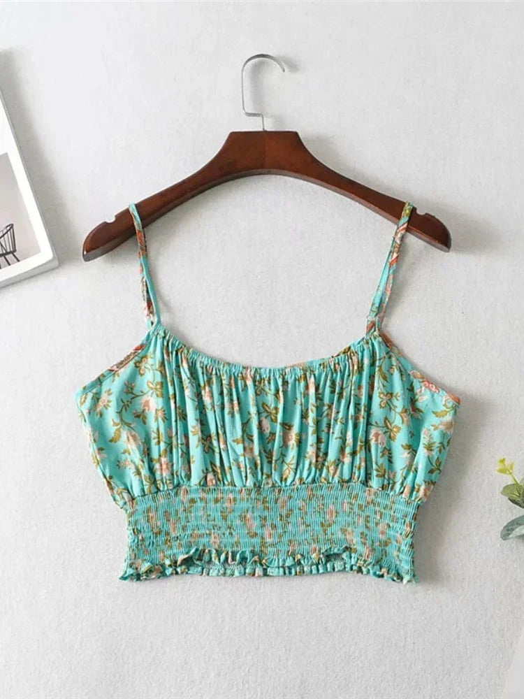 Teal floral flowy crop top with a gathered bodice and smocked waist, hanging on a wooden hanger for summer outings.