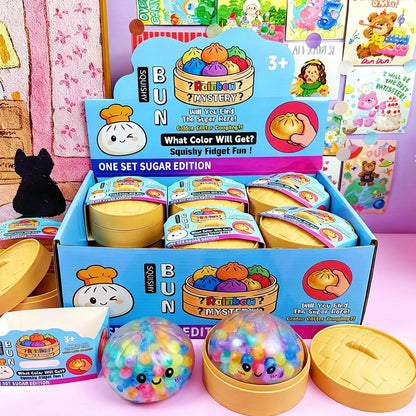 Multi-colored, soft foam dumpling steamed bun slow rising squishy fidget toy in a yellow plastic steamer basket.