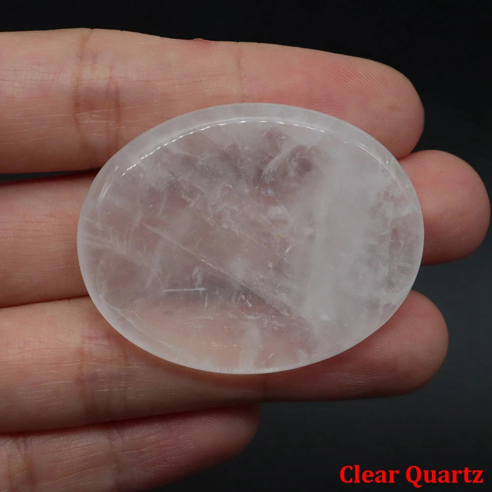 Smooth, translucent clear quartz palm stone held in hand for meditation home decor.