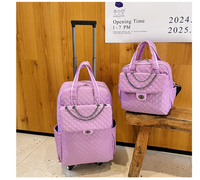 Two purple quilted nylon rolling luggage bags with chain accents and dual top handles.