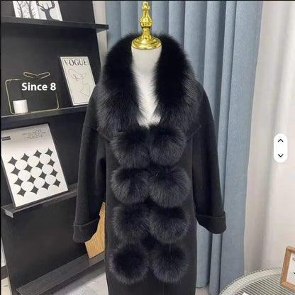 Black faux fox fur scarf with plush pom-poms on a black coat, worn on a mannequin.