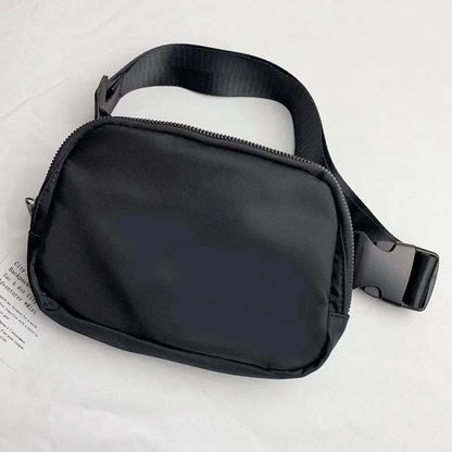 Black waterproof crossbody bag with zip closure and adjustable strap for running and yoga.