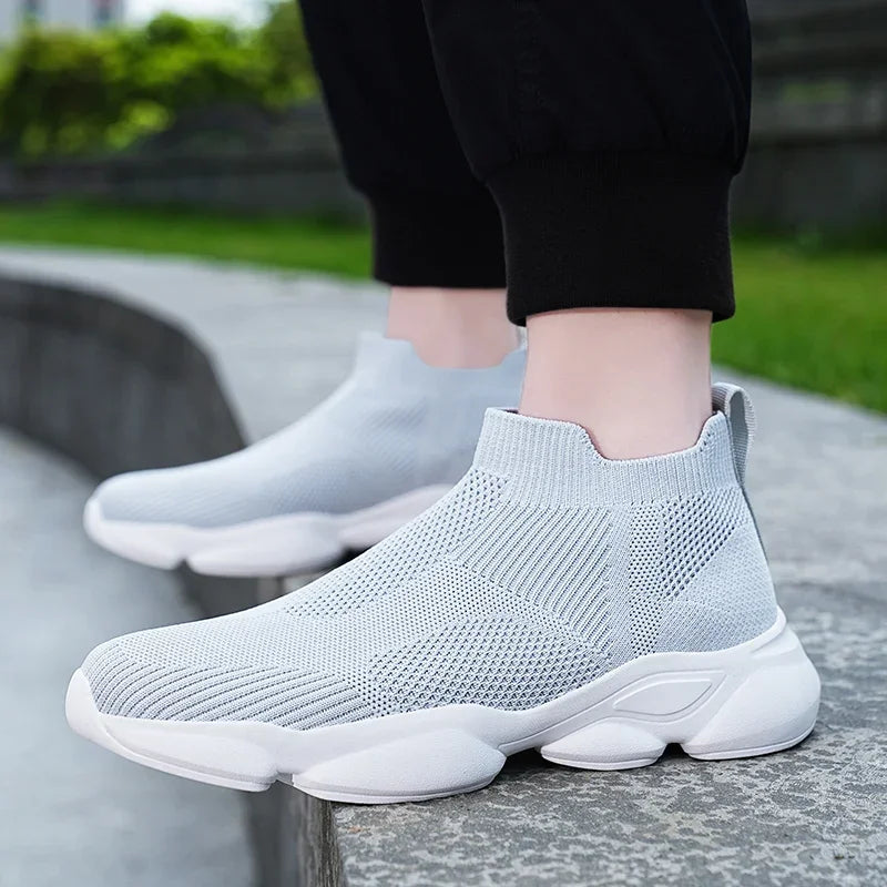 Light gray breathable knit moccasin sneakers with a white platform sole for casual walking.