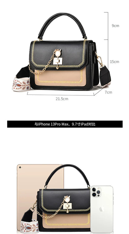 Black and beige faux leather handbag with gold chain detail, top handle, and patterned strap.
