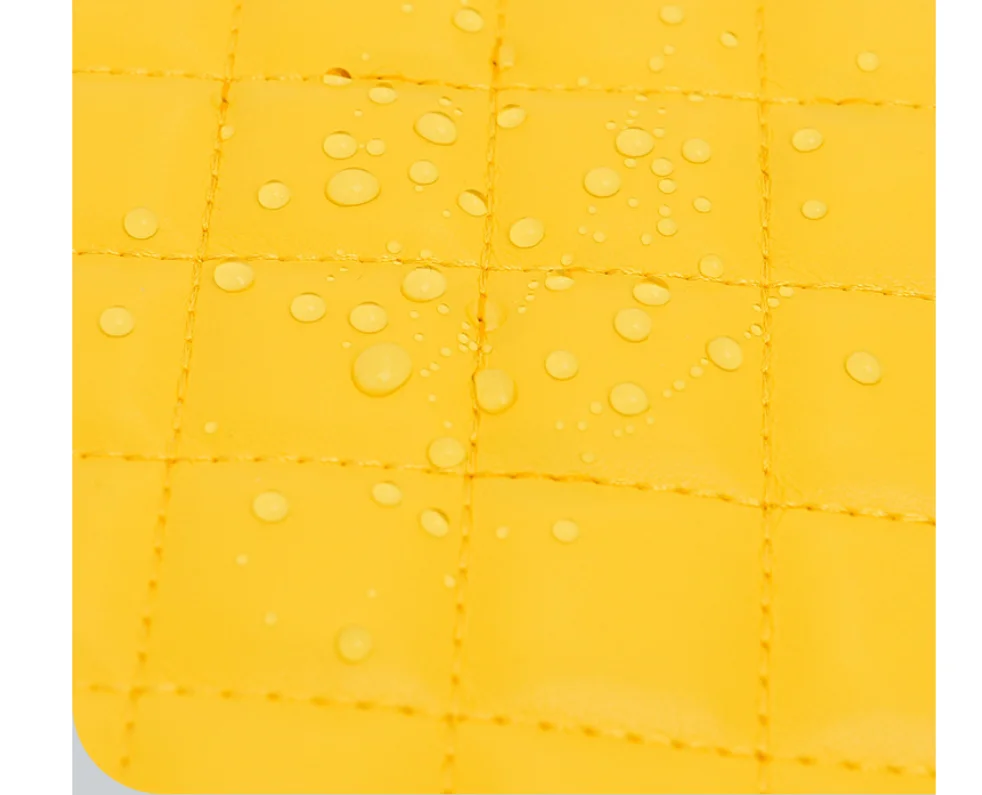 Water-resistant yellow quilted nylon fabric with water droplets beading on the surface.
