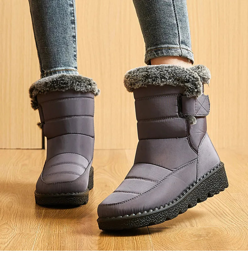 Grey quilted snow boots with faux fur trim, low heels, and black rubber lug soles worn with jeans.